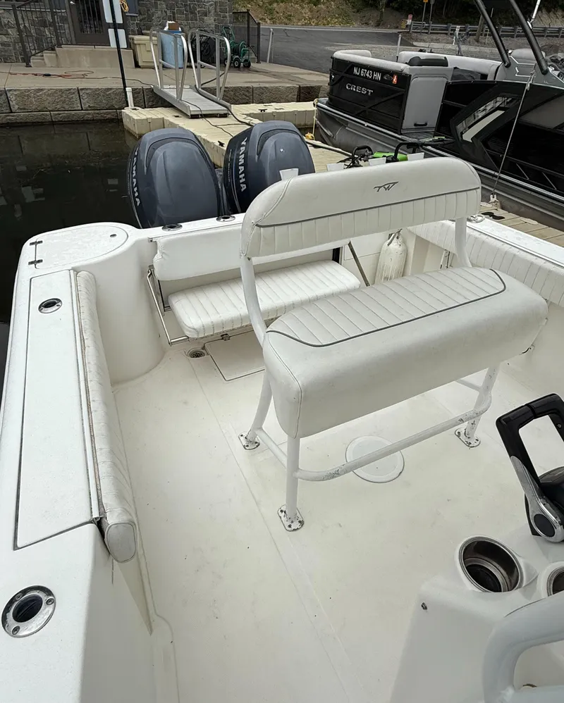 Slide: The Image of 2011 Tidewater 250CC Adventure boat with twin engines, white seating, and docked at a marina. - 8