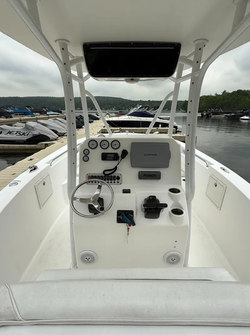 Slide: The Image of 2011 Tidewater 250CC Adventure Twin Engine boat dashboard at marina, featuring steering wheel and controls. - 9
