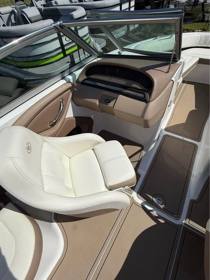 Slide: The Image of 2012 Cobalt 242 boat interior with beige and white seating, sleek dashboard, and windshield. - 10