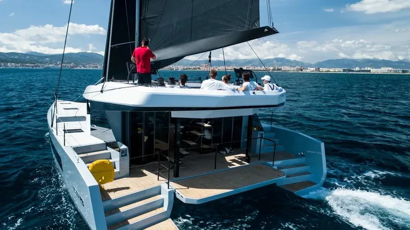 Slide: The Image of 2026 McConaghy MC55 catamaran sailing with passengers on a sunny day. - 4