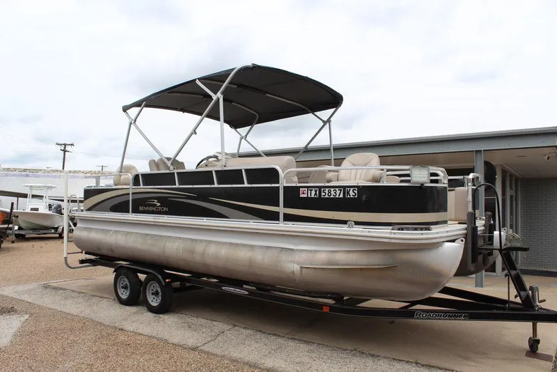 Slide: The Image of 2010 Bennington 2275 Fish pontoon boat on trailer, featuring a canopy and spacious seating. - 0