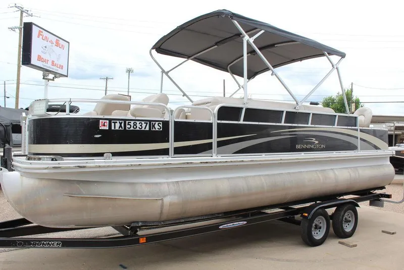 Slide: The Image of 2010 Bennington 2275 Fish pontoon boat on trailer, featuring a canopy and sleek design. - 14
