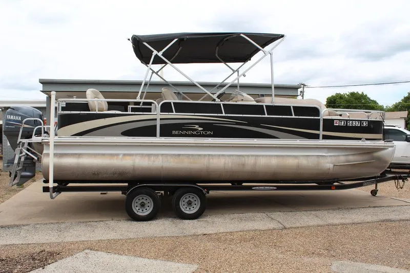 Slide: The Image of 2010 Bennington 2275 Fish pontoon boat on trailer with canopy, parked outdoors. - 21