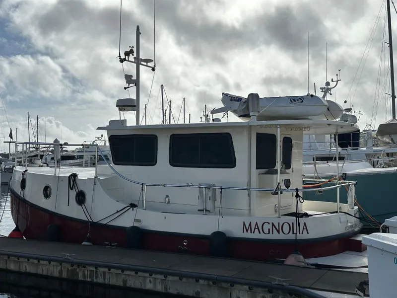 Slide: The Image of 2005 Great Harbour N37 boat "Magnolia" docked at marina under cloudy sky. - 1