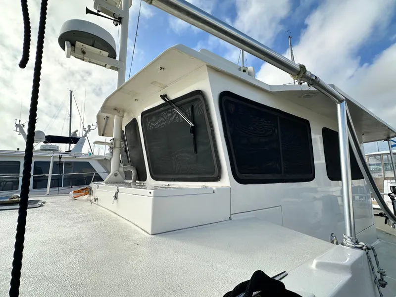 Slide: The Image of 2005 Great Harbour N37 boat with white exterior and tinted windows, docked under a cloudy sky. - 13