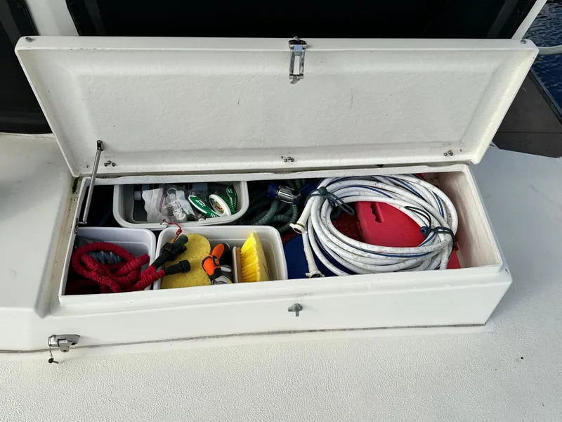 Slide: The Image of Open storage compartment on 2005 Great Harbour N37 boat with ropes and cleaning supplies. - 28