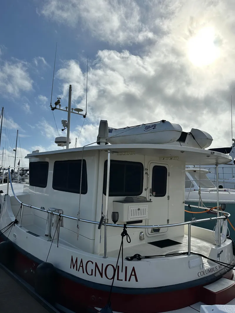 Slide: The Image of 2005 Great Harbour N37 boat "Magnolia" docked under a cloudy sky. - 3