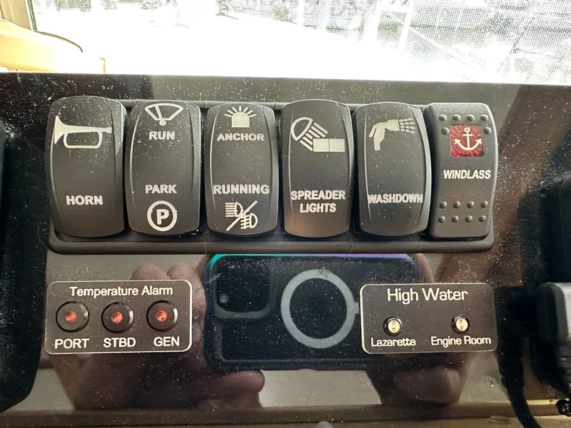 Slide: The Image of Control panel of a 2005 Great Harbour N37 boat with various switches and alarms. - 46