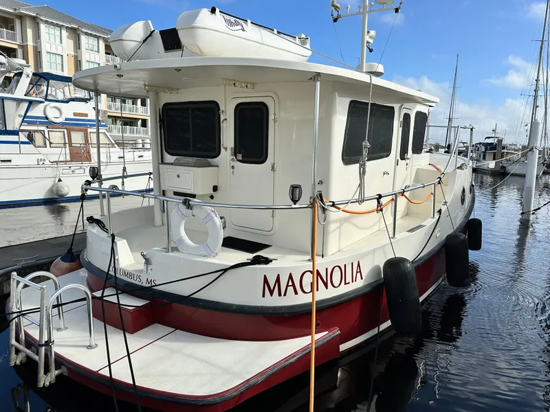 Slide: The Image of 2005 Great Harbour N37 boat "Magnolia" docked at marina, featuring white and red design. - 7