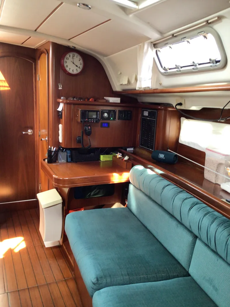 Slide: The Image of Interior of 2000 Beneteau Oceanis 40 yacht with wooden finish and teal seating. - 11