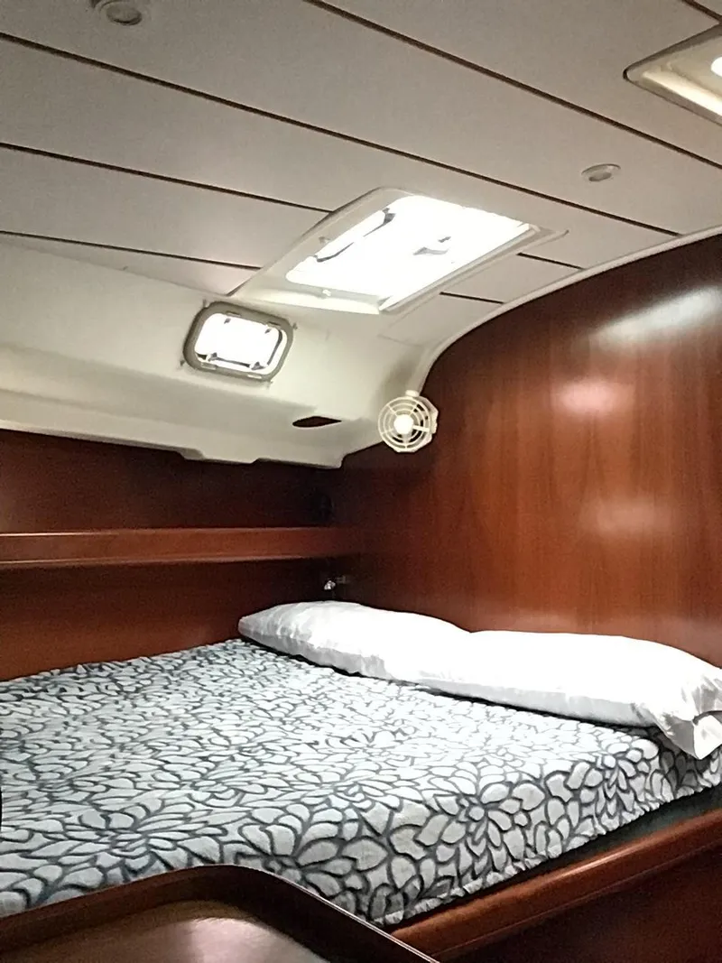 Slide: The Image of Cozy cabin interior of 2000 Beneteau Oceanis 40 sailboat with wooden finish and bedding. - 15