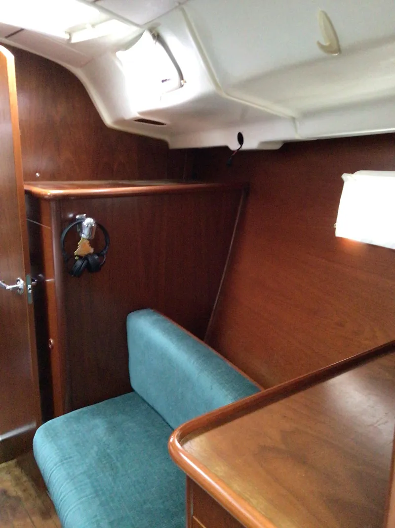 Slide: The Image of Interior of 2000 Beneteau Oceanis 40 sailboat with wooden paneling and teal seating. - 16