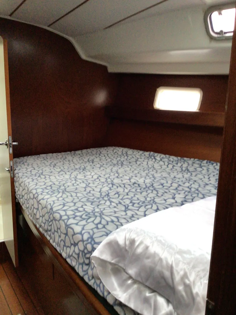 Slide: The Image of Cozy cabin interior of 2000 Beneteau Oceanis 40 sailboat with patterned bedding. - 17