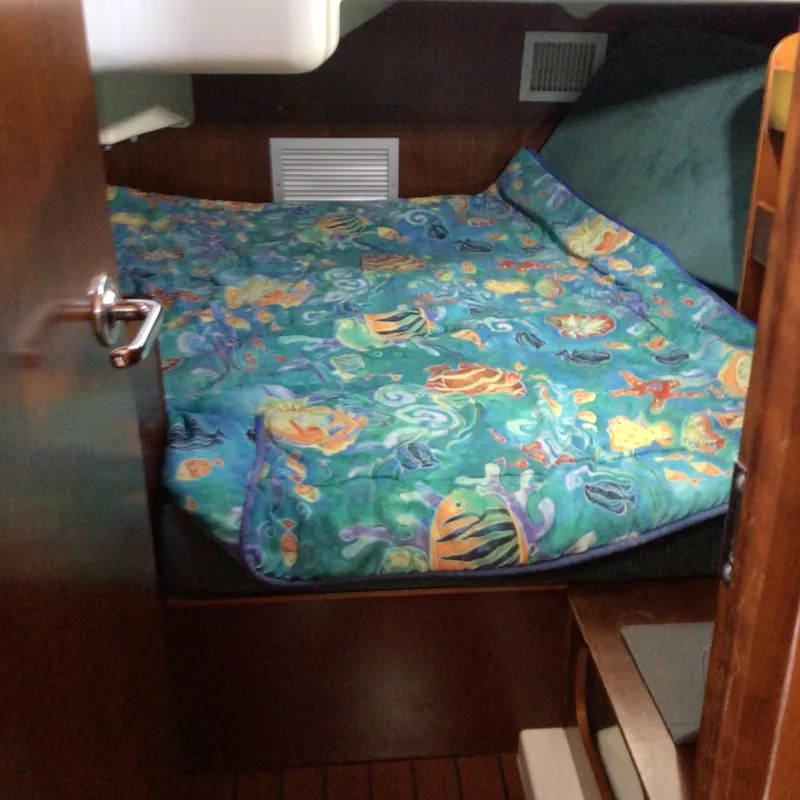 Slide: The Image of Cozy cabin interior of 2000 Beneteau Oceanis 40 with colorful marine-themed bedding. - 20