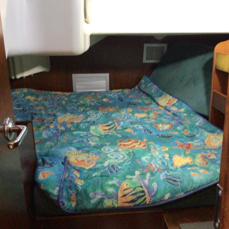 Slide: The Image of Cozy cabin interior of 2000 Beneteau Oceanis 40 with colorful marine-themed bedding. - 23