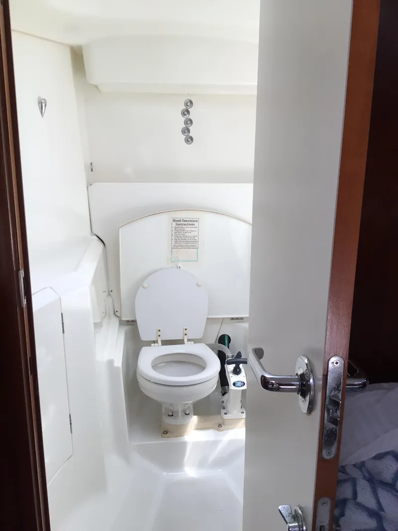 Slide: The Image of Beneteau Oceanis 40 (2000) yacht bathroom with white marine toilet and compact design. - 24