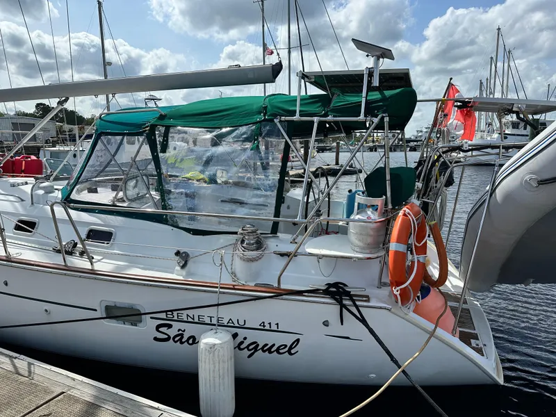 Slide: The Image of Beneteau Oceanis 40 sailboat docked, featuring green canopy and lifebuoy, year 2000 model. - 3