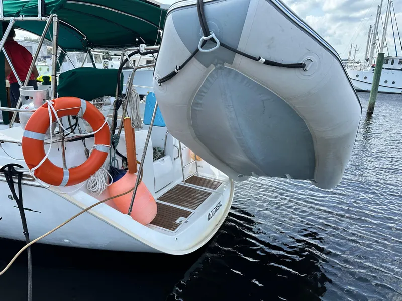 Slide: The Image of Beneteau Oceanis 40 sailboat, 2000 model, with lifebuoy and dinghy at marina. - 5