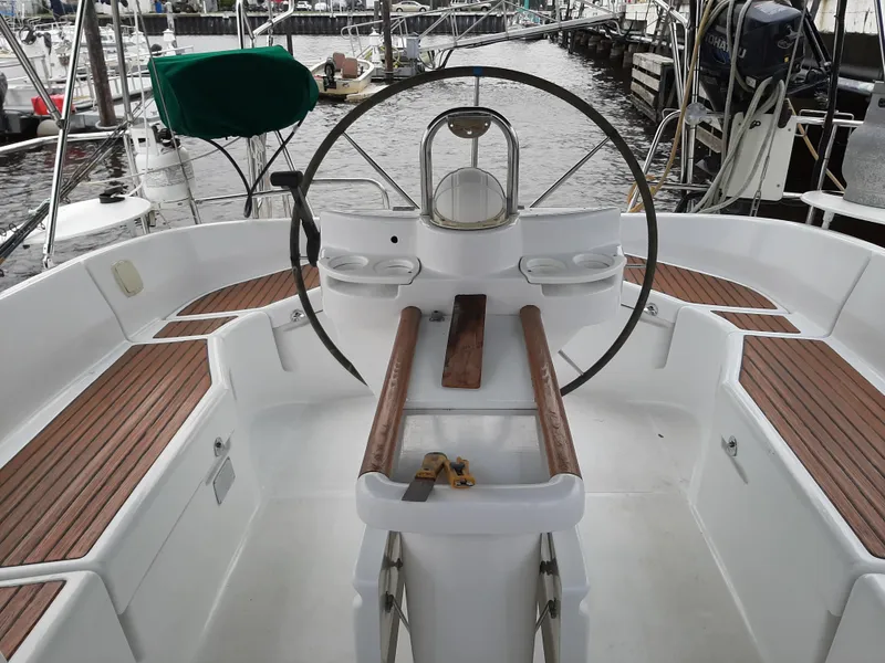 Slide: The Image of Cockpit of a 2000 Beneteau Oceanis 40 sailboat with wooden seating and steering wheel. - 8