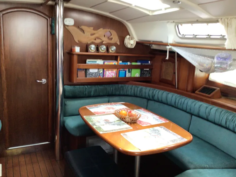 Slide: The Image of Interior of 2000 Beneteau Oceanis 40 sailboat with cozy seating and wooden accents. - 9