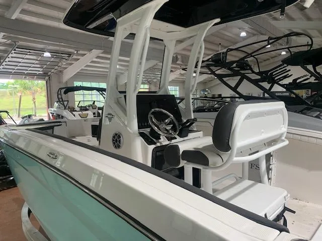 Slide: The Image of 2024 Yamaha Boats 252 FSH Sport in showroom, featuring sleek design and modern console. - 2