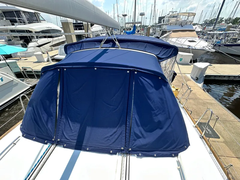 Slide: The Image of Beneteau Oceanis 45 sailboat, 2014 model, with blue canvas cover docked at marina. - 19
