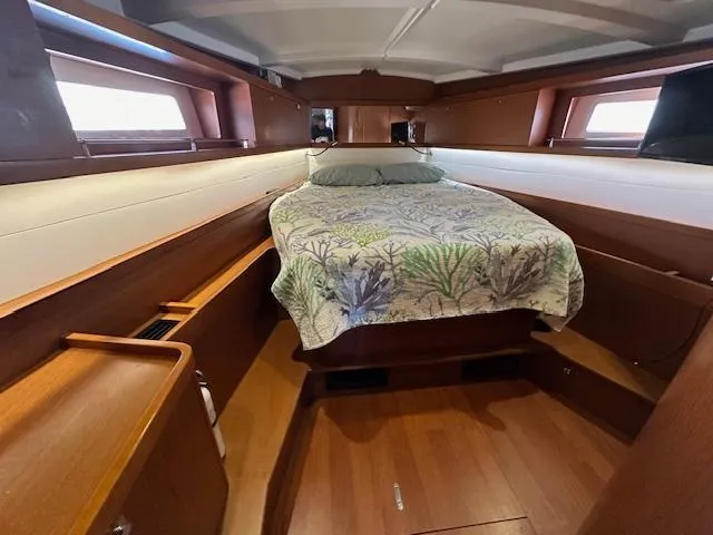 Slide: The Image of Cozy cabin interior of 2014 Beneteau Oceanis 45 sailboat with bed and wooden finish. - 48