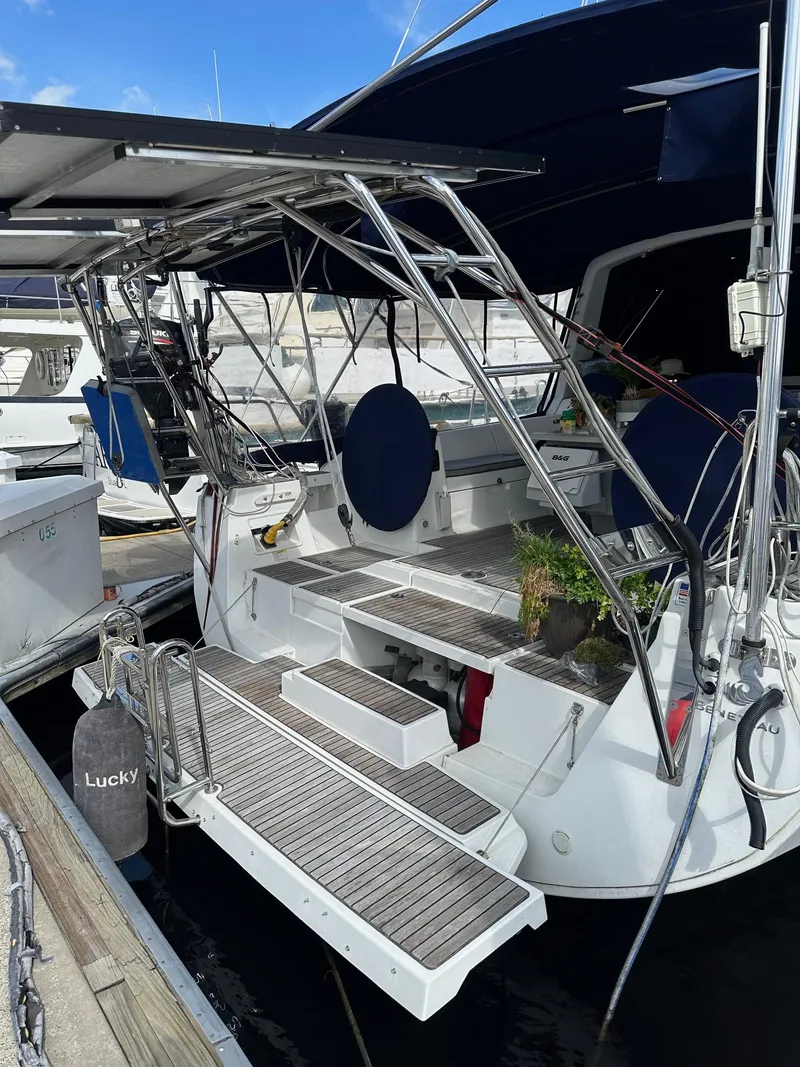 Slide: The Image of Beneteau Oceanis 45 sailboat, 2014 model, docked with open transom and blue canopy. - 6