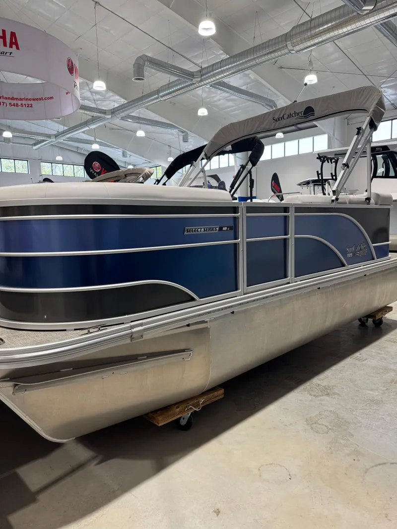 Slide: The Image of 2024 G3 Select 18C pontoon boat in showroom, featuring sleek blue and silver design. - 1