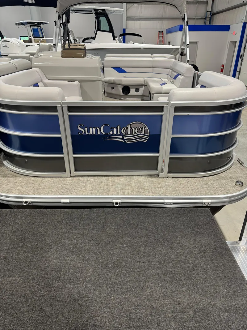 Slide: The Image of 2024 G3 Select 18C SunCatcher pontoon boat with blue and white seating in showroom. - 4