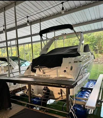 Slide: The Image of 2022 Monterey 295 Sport Yacht docked under a covered marina. - 0