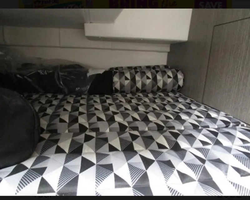 Slide: The Image of 2022 Monterey 295 Sport Yacht interior with geometric-patterned bedding. - 14
