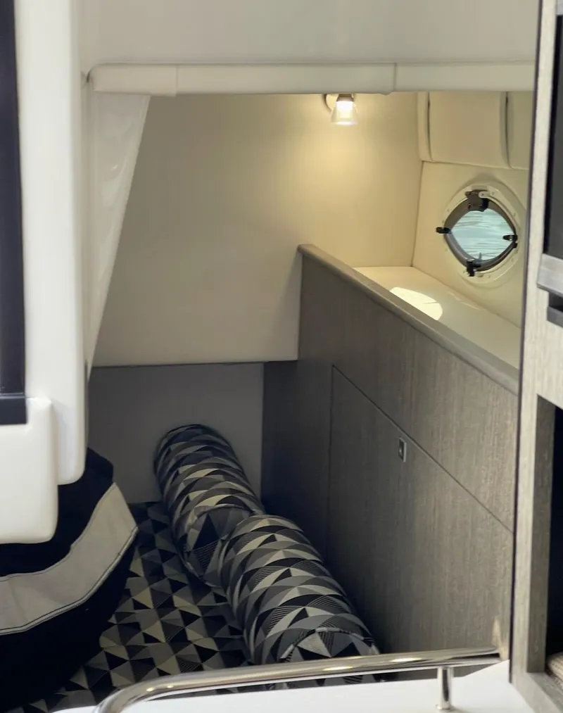 Slide: The Image of 2022 Monterey 295 Sport Yacht interior cabin with modern design and geometric-patterned cushions. - 17