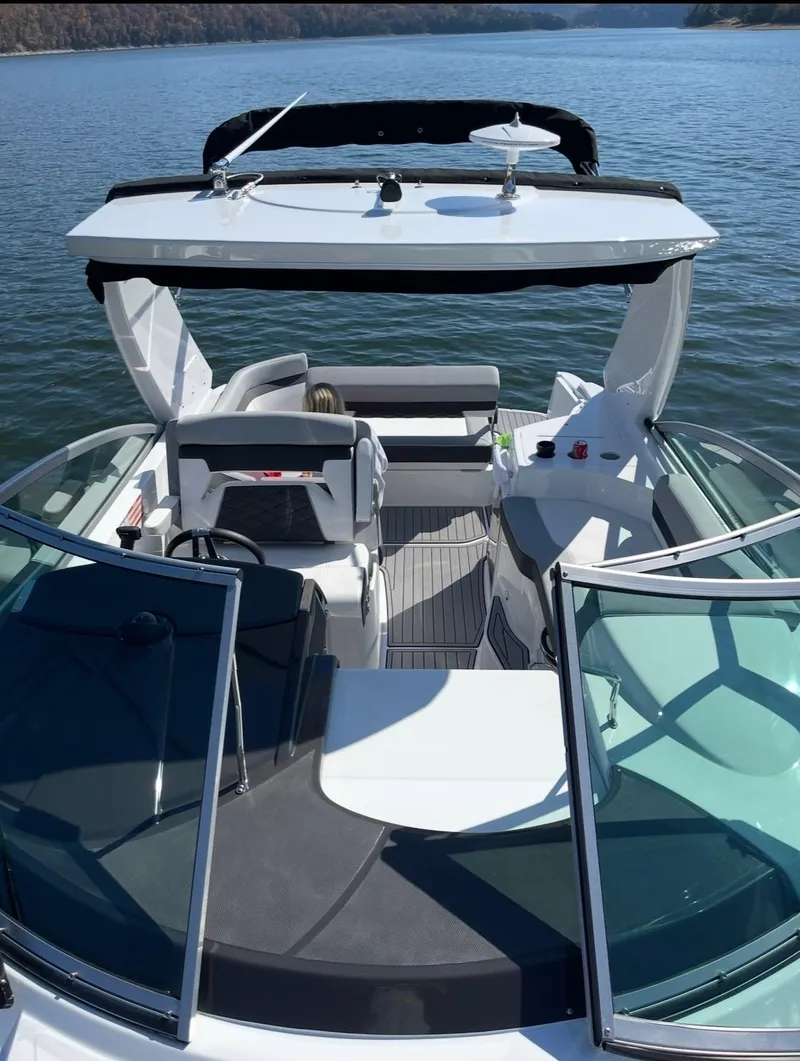 Slide: The Image of 2022 Monterey 295 Sport Yacht on serene lake, showcasing sleek design and spacious deck. - 4