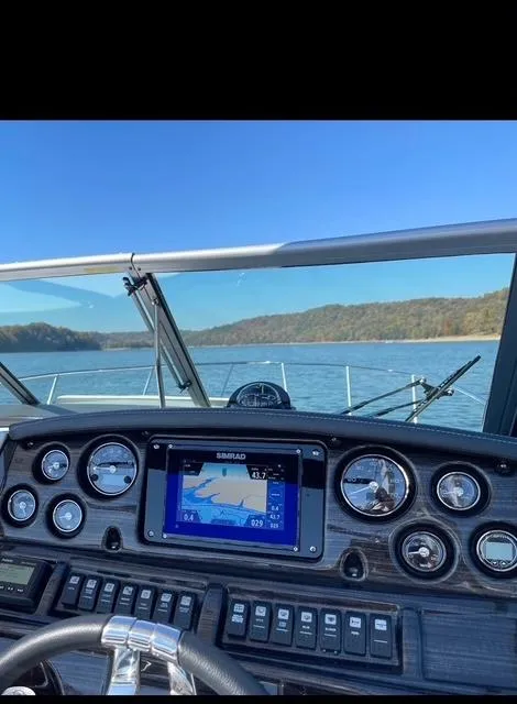 Slide: The Image of 2022 Monterey 295 Sport Yacht dashboard with navigation system on a scenic lake. - 5