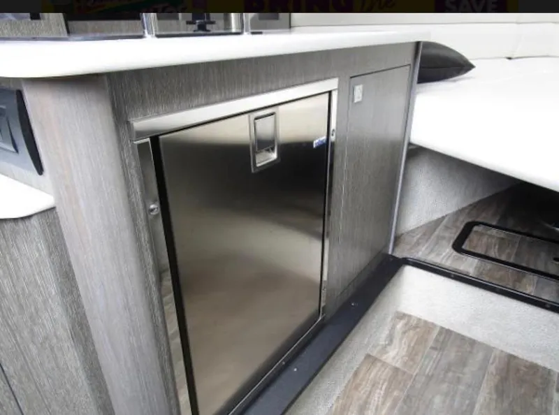Slide: The Image of 2022 Monterey 295 Sport Yacht interior with sleek cabinetry and stainless steel fridge. - 7