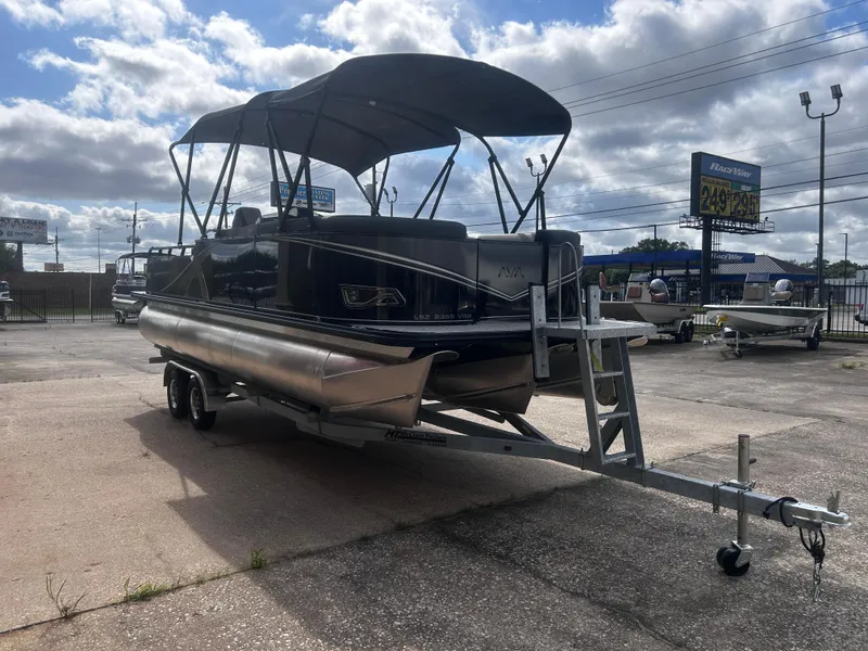 Slide: The Image of 2025 Avalon LSZ VRB23T DX pontoon boat on trailer under cloudy sky. - 6