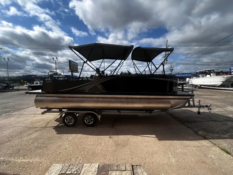 Slide: The Image of 2025 Avalon LSZ VRB23T DX pontoon boat on trailer under cloudy sky. - 7