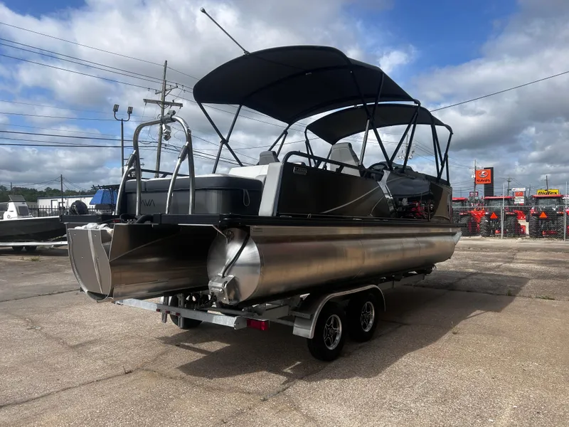 Slide: The Image of 2025 Avalon LSZ VRB23T DX pontoon boat on trailer, parked outdoors under cloudy sky. - 8