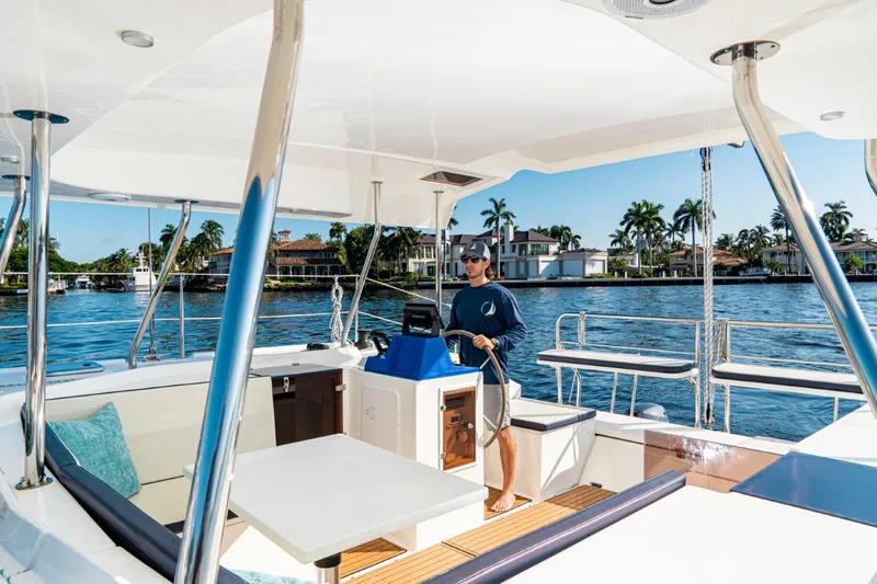 Slide: The Image of Man steering 2025 Smart Cat M280 Power boat on a sunny day, near waterfront homes. - 15