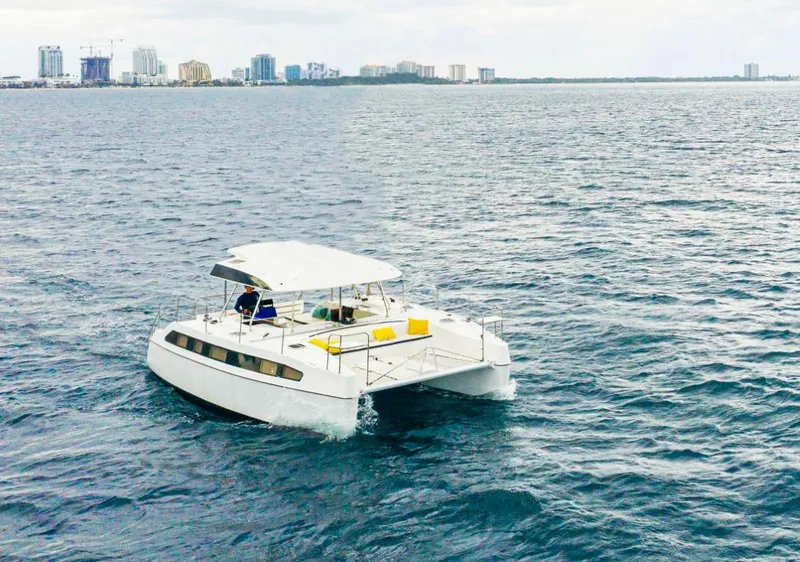 The Image of 2025 Smart Cat M280 Power catamaran cruising on open water near city skyline. - 0