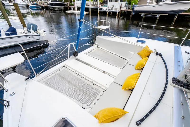 Slide: The Image of Catamaran deck with yellow cushions, Smart Cat M280 Power, 2025 model, docked by the water. - 24