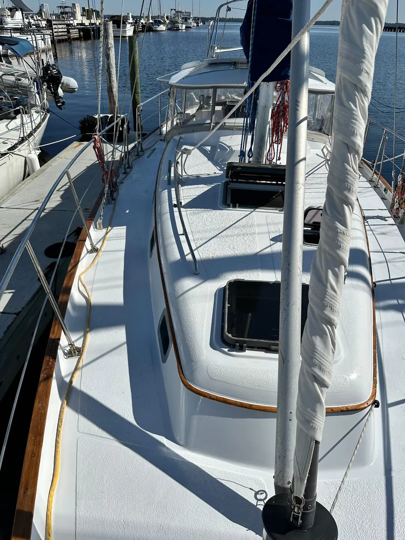 Slide: The Image of 1981 Kelly Peterson 44 sailboat docked at marina, showcasing deck and rigging. - 12