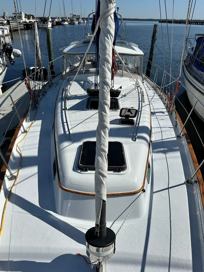 Slide: The Image of 1981 Kelly Peterson 44 sailboat deck view at marina, clear sky, calm water. - 13