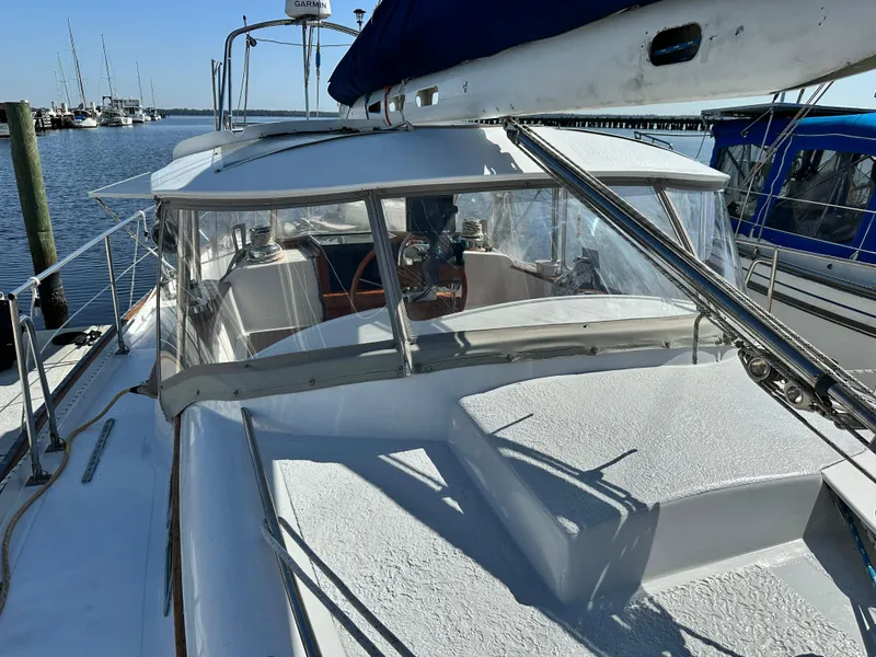 Slide: The Image of 1981 Kelly Peterson 44 sailboat docked at marina, featuring cockpit and clear canopy. - 15