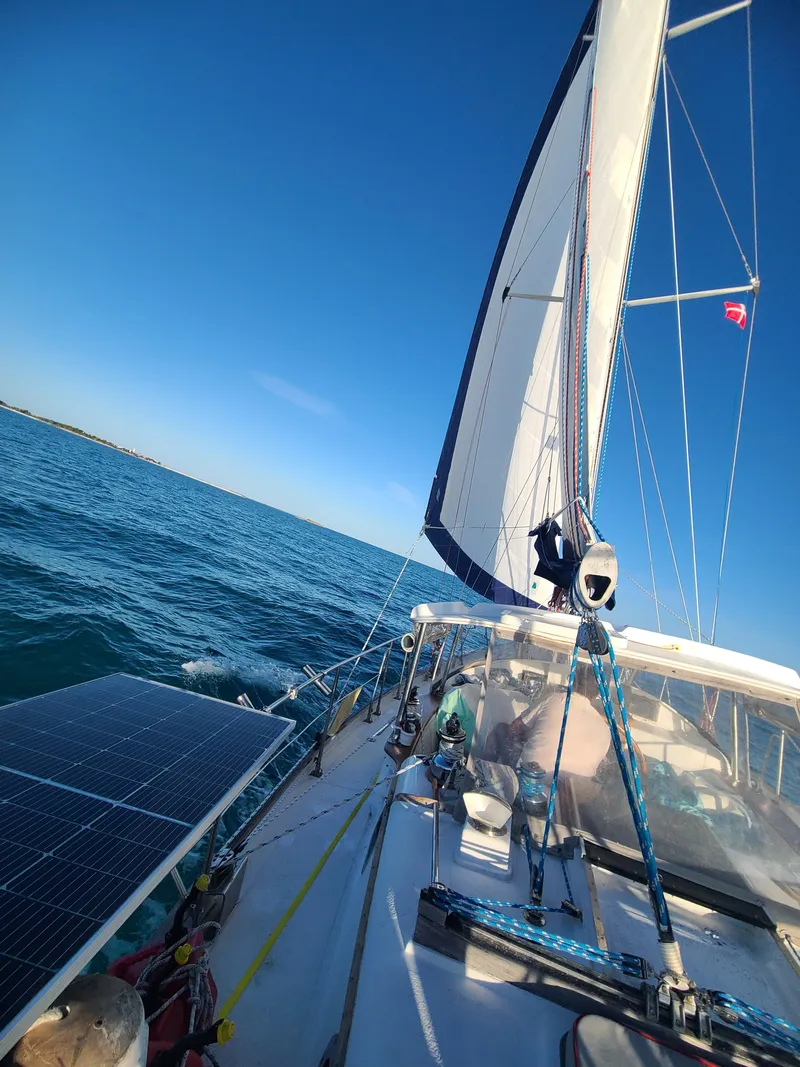 Slide: The Image of Sailing on a 1981 Kelly Peterson 44 yacht with solar panels under clear blue skies. - 19