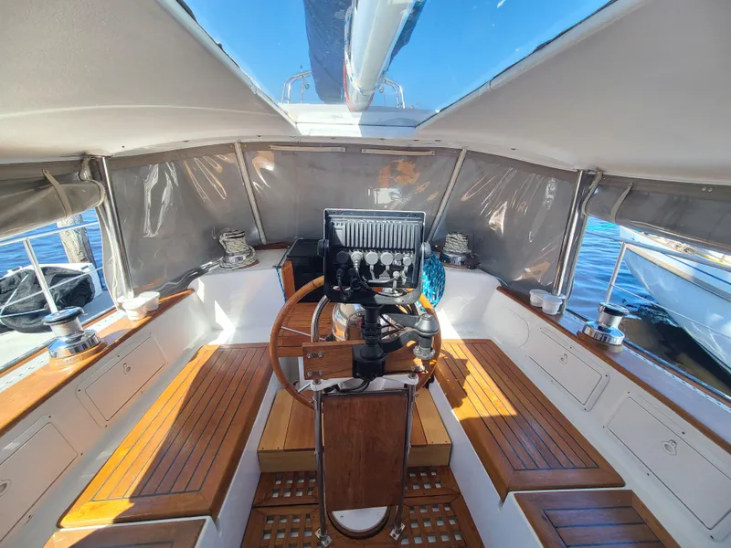 Slide: The Image of Interior view of 1981 Kelly Peterson 44 sailboat cockpit with wooden seating and steering wheel. - 23