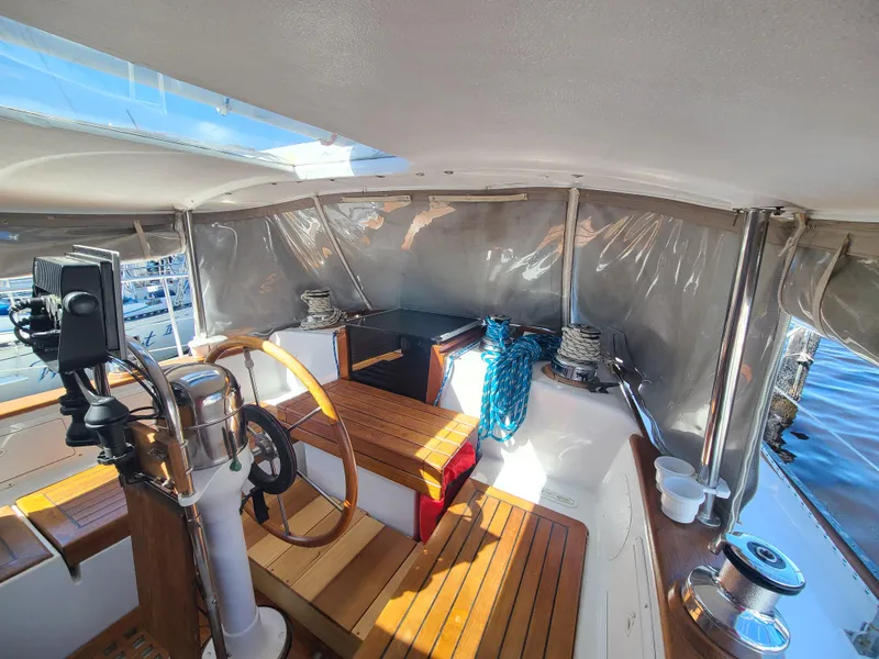 Slide: The Image of Cockpit of 1981 Kelly Peterson 44 sailboat with wooden steering wheel and nautical equipment. - 25