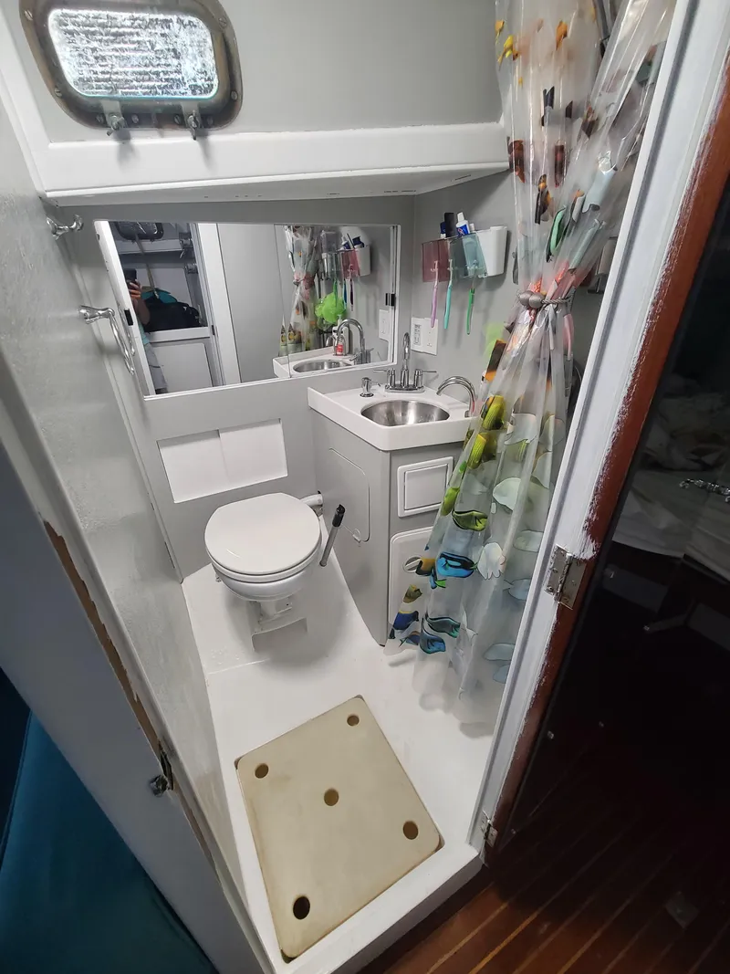 Slide: The Image of Compact bathroom in a 1981 Kelly Peterson 44 sailboat, featuring a toilet, sink, and shower. - 40