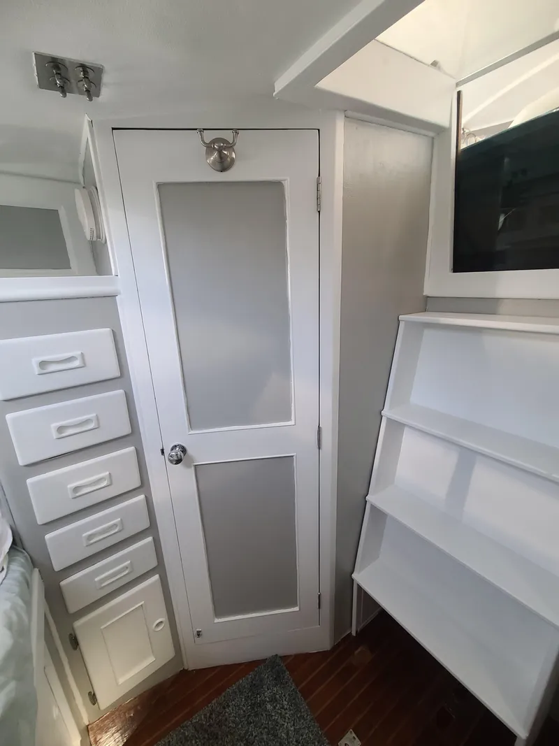 Slide: The Image of Interior of a 1981 Kelly Peterson 44 yacht with white cabinetry and shelving. - 43